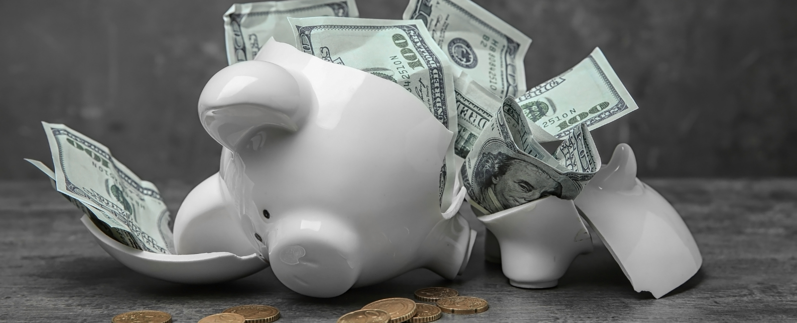 Broken piggy bank leaking out money